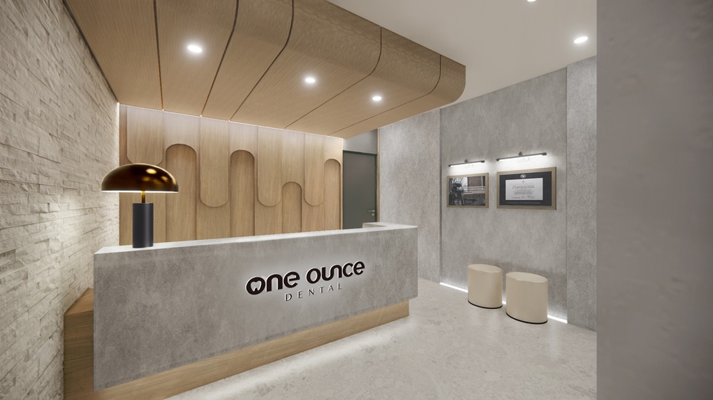 One Ounce Dental reception area with a branded front desk, warm wood accents, and modern lighting in Chino, CA